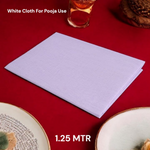 A neatly folded pure white cotton cloth used for Hindu rituals and poojas, displayed on a wooden surface