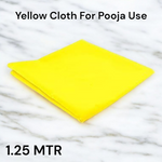 Bright yellow cotton cloth neatly folded and placed on a wooden surface for pooja and religious use