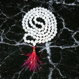 Close-up image of a premium 108+1 bead Sphatik (Crystal) Mala with 8MM beads, hand-knotted, radiant clear quartz beads, laid out on a white background