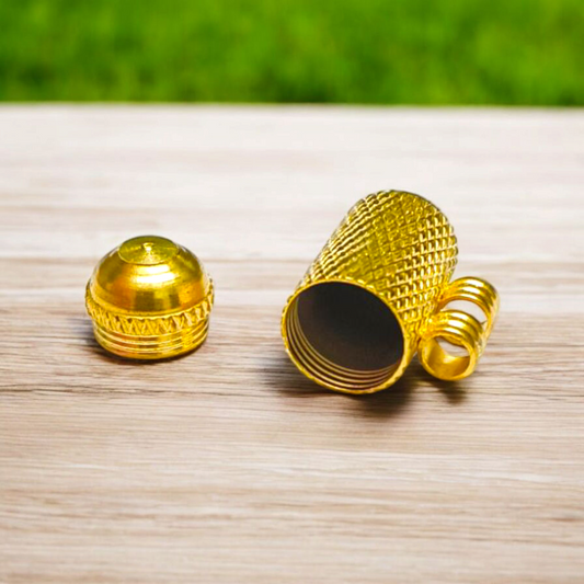 Five golden metal cylindrical taweez neatly arranged with Bhojpatra sheets on a clean white surface
