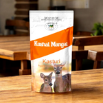 Hand-rolled Kasturi incense sticks with traditional Indian packaging placed beside a lit diya and fresh marigold flowers