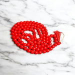 Handcrafted Red Hakik Mala made with natural Red Agate beads in 27+1 and 108+1 variants, placed on a wooden surface with lab certificate