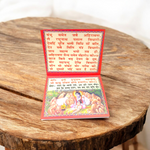 Hanuman Chalisa Hindi Book with colourful pages and devotional cover art placed near diya and flowers