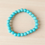Image of a stretchable turquoise gemstone bracelet made with smooth 8mm beads on a white background
