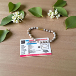 Image of two stretchable bracelets – one made with white Vaijanti seeds and one with yellow Haldi beads – arranged side by side on a natural background