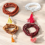 Image showing a set of 4 Jaap Malas – Rudraksha, White Sandalwood, Sphatik, and Red Sandalwood – neatly arranged on a traditional spiritual cloth
