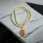 Moti mala with white pearls and Radha Krishna locket placed on a velvet cloth background