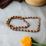 Natural 5 Face Rudraksha Mala with 50 golden-capped 6mm beads, handcrafted and lab-certified, ideal for meditation and daily wear with 1-year plating guarantee