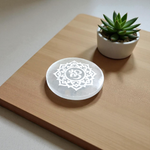 Selenite charging plate with engraved Om symbol, polished round design for pooja, décor, and crystal cleansing