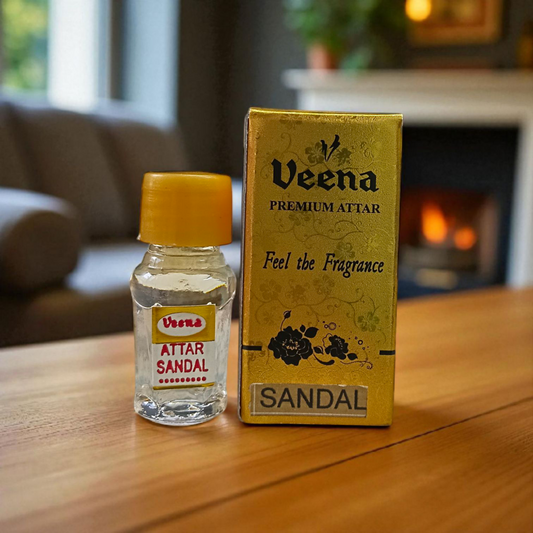 Small glass vial of 2ML Sandal Attar by Veena, MALAWALA brand, with golden cap and traditional label, placed on a wooden background with sandalwood chips