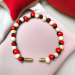 Stretchable bracelet made of natural red and white Gunja seeds, 5mm beads, displayed on a white background