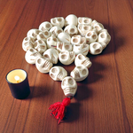 Traditional Nar Mund Mala with skull-shaped beads tied in red thread, arranged on a dark spiritual altar cloth