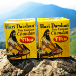 Two plastic containers of Hari Darshan Kumkum and Chandan Tilak with vibrant red and beige paste used for religious markings