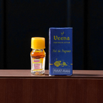 1ML bottle of Raat Rani Attar with applicator placed beside night-blooming jasmine flowers and diya lamp on a wooden altar