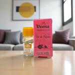 2ML bottle of Gulab Attar by Veena, a handcrafted rose perfume for spiritual and daily use, placed with rose petals