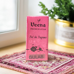 2ML bottle of Gulab Attar by Veena, a handcrafted rose perfume for spiritual and daily use, placed with rose petals