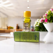 A 2ML roll-on bottle of Janat-UL-Firdaus Attar by Veena, placed alongside aromatic herbs and floral elements, symbolizing purity and spirituality