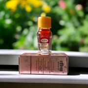 A 2ML roll-on bottle of Veena’s Musk Amber Attar placed elegantly with natural ingredients in the background, showcasing luxury and tradition