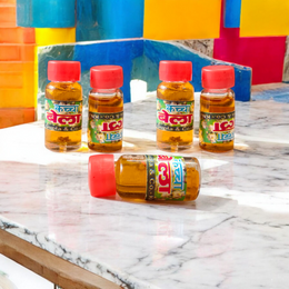 A 4ML roll-on bottle of Bela Attar by Veena, placed with jasmine (Bela) flowers on a wooden surface, symbolizing purity, peace, and tradition