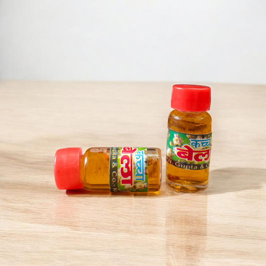 A 4ML roll-on bottle of Bela Attar by Veena, placed with jasmine (Bela) flowers on a wooden surface, symbolizing purity, peace, and tradition