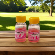 A 4ML roll-on bottle of Gulab Attar by Veena, displayed with rose petals around it, symbolizing purity, romance, and timeless floral elegance