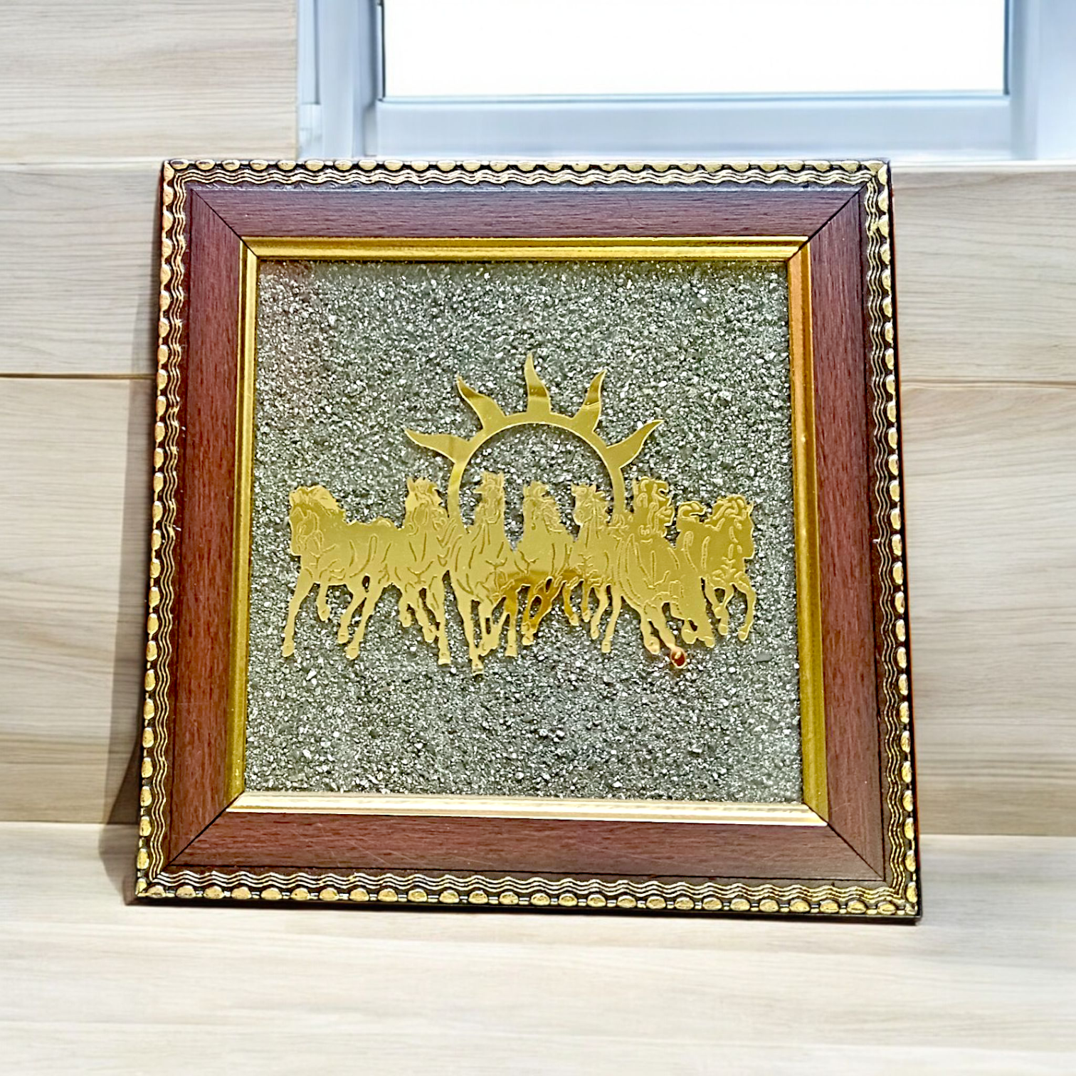 A 7x7 inch wooden Vastu frame featuring seven golden horses running toward the rising sun with a centrally placed Pyrite stone, ideal for wealth and energy correction