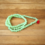 A Lab Certified Green Moti Mala made of 108+1 smooth, round green pearl beads, strung for japa, meditation, and spiritual healing