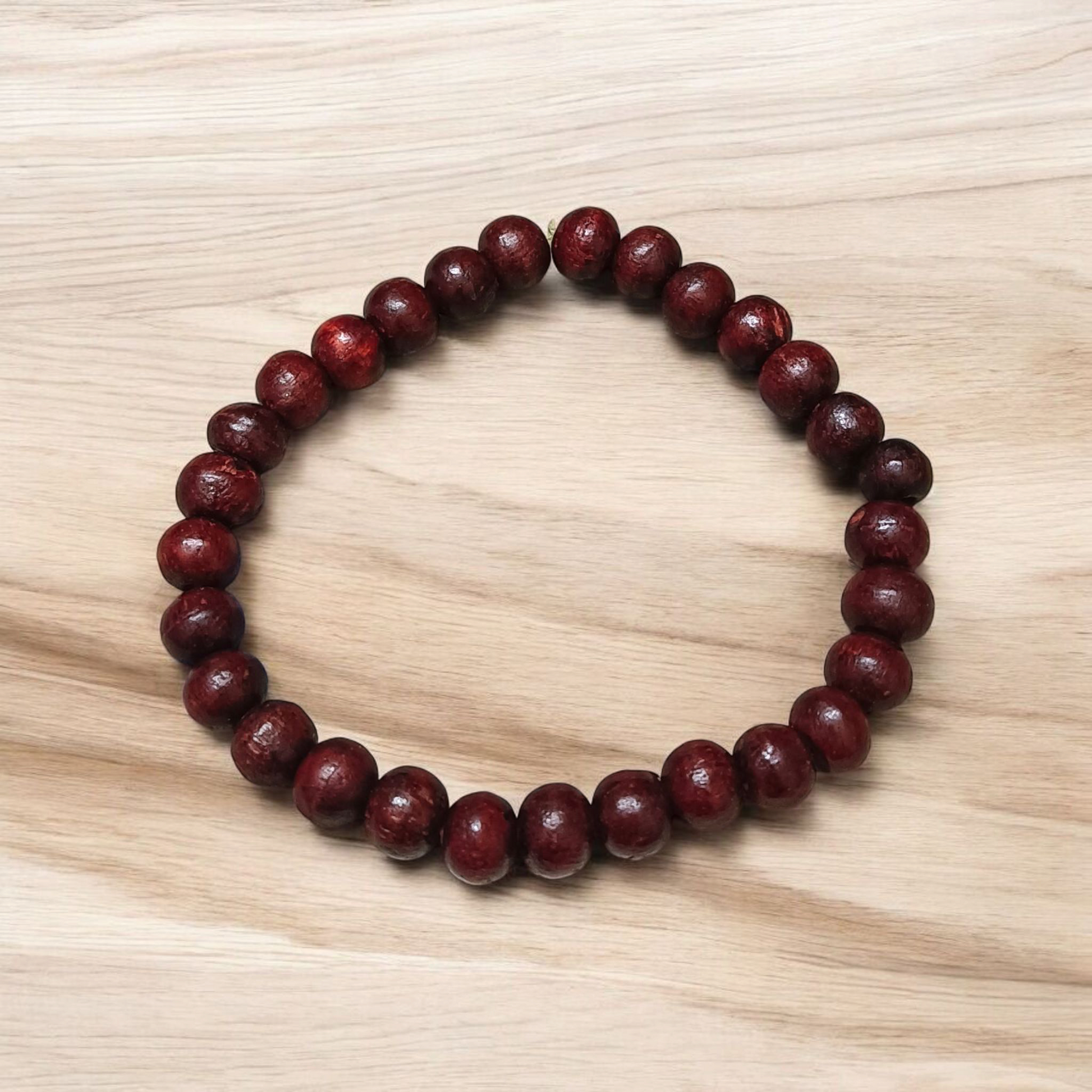 A Natural Red Sandalwood (Lal Chandan) Bracelet with 8mm polished beads, strung on stretchable thread, ideal for meditation and spiritual practice