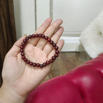 A Natural Red Sandalwood (Lal Chandan) Bracelet with 8mm polished beads, strung on stretchable thread, ideal for meditation and spiritual practice