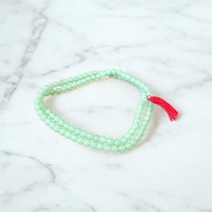 A beautiful 108+1 bead Green Moti Mala made of small, smooth pearl-like green beads strung for japa or spiritual wear