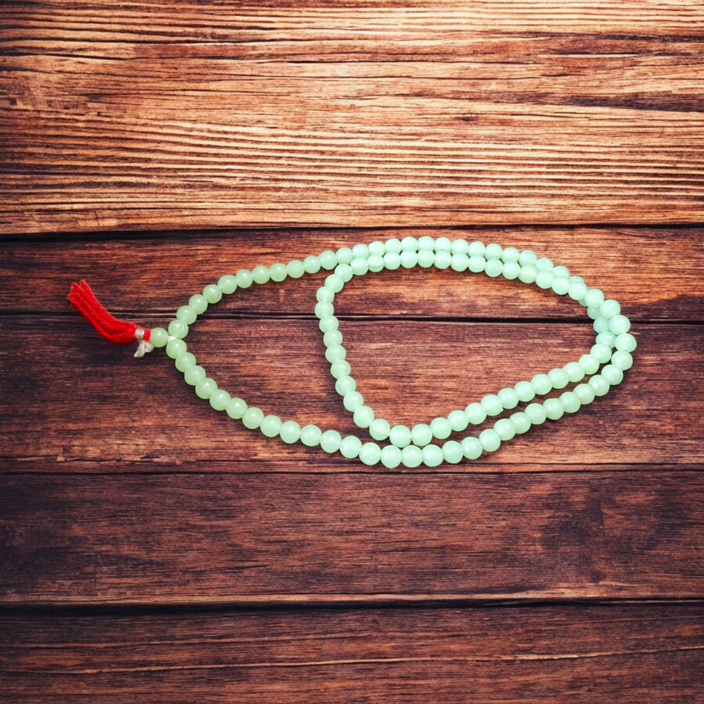 A beautiful 108+1 bead Green Moti Mala made of small, smooth pearl-like green beads strung for japa or spiritual wear