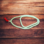 A beautiful 108+1 bead Green Moti Mala made of small, smooth pearl-like green beads strung for japa or spiritual wear