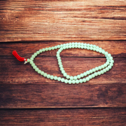 A beautiful 108+1 bead Green Moti Mala made of small, smooth pearl-like green beads strung for japa or spiritual wear