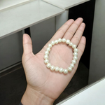 A beautiful 8mm stretchable natural pearl bracelet featuring round, white freshwater pearls on an elastic cord, ideal for healing and style