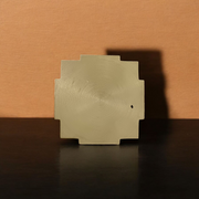 A beautifully crafted brass Meru Shri Yantra placed on a wooden pooja altar, with intricate geometric detailing and divine presence