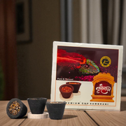 A box of MALAWALA Premium Cup Sambrani containing 12 natural dhoop cups arranged neatly, with one cup lit and emitting aromatic smoke