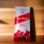 A bundle of hand-rolled Rose Incense Sticks by Kushal Mangal, placed on a holder with light smoke, symbolizing peace and natural fragrance