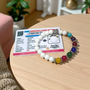 A handcrafted 7 Chakra Bracelet with White Agate and Howlite beads arranged in a circular elastic design, ideal for spiritual healing and meditation