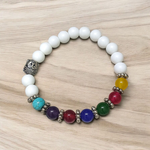 A handcrafted 7 Chakra Bracelet with White Agate and Howlite beads arranged in a circular elastic design, ideal for spiritual healing and meditation