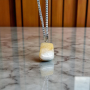 A handcrafted Yellow Aventurine stone pendant with a polished oval gemstone set in a sleek metal frame, suitable for men and women