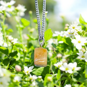 A handcrafted Yellow Aventurine stone pendant with a polished oval gemstone set in a sleek metal frame, suitable for men and women