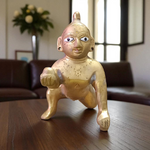 A handcrafted brass Laddu Gopal statue in crawling pose, available in sizes 0 to 6, ideal for temple and home worship