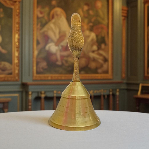 A handcrafted brass pooja bell with Garuda engravings, ideal for temple and home rituals
