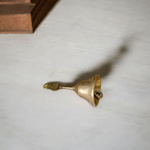 A handcrafted brass pooja bell with Garuda engravings, ideal for temple and home rituals