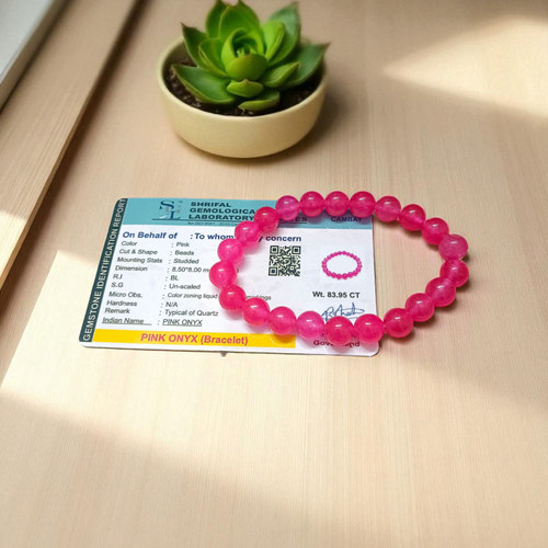 A handcrafted stretchable Pink Onyx bracelet with 8mm light pink beads arranged in a circle on a white background