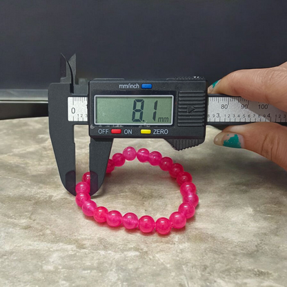 A handcrafted stretchable Pink Onyx bracelet with 8mm light pink beads arranged in a circle on a white background