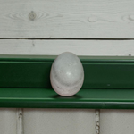 A handcrafted white and black marble Shivling placed on a clean surface, ideal for Tulsi or temple worship