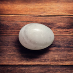 A handcrafted white and black marble Shivling placed on a clean surface, ideal for Tulsi or temple worship