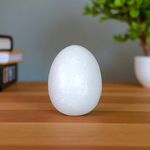 A handcrafted white marble Shivling stone, smooth and polished, ideal for placing under Tulsi plant, home temple, or personal worship altar
