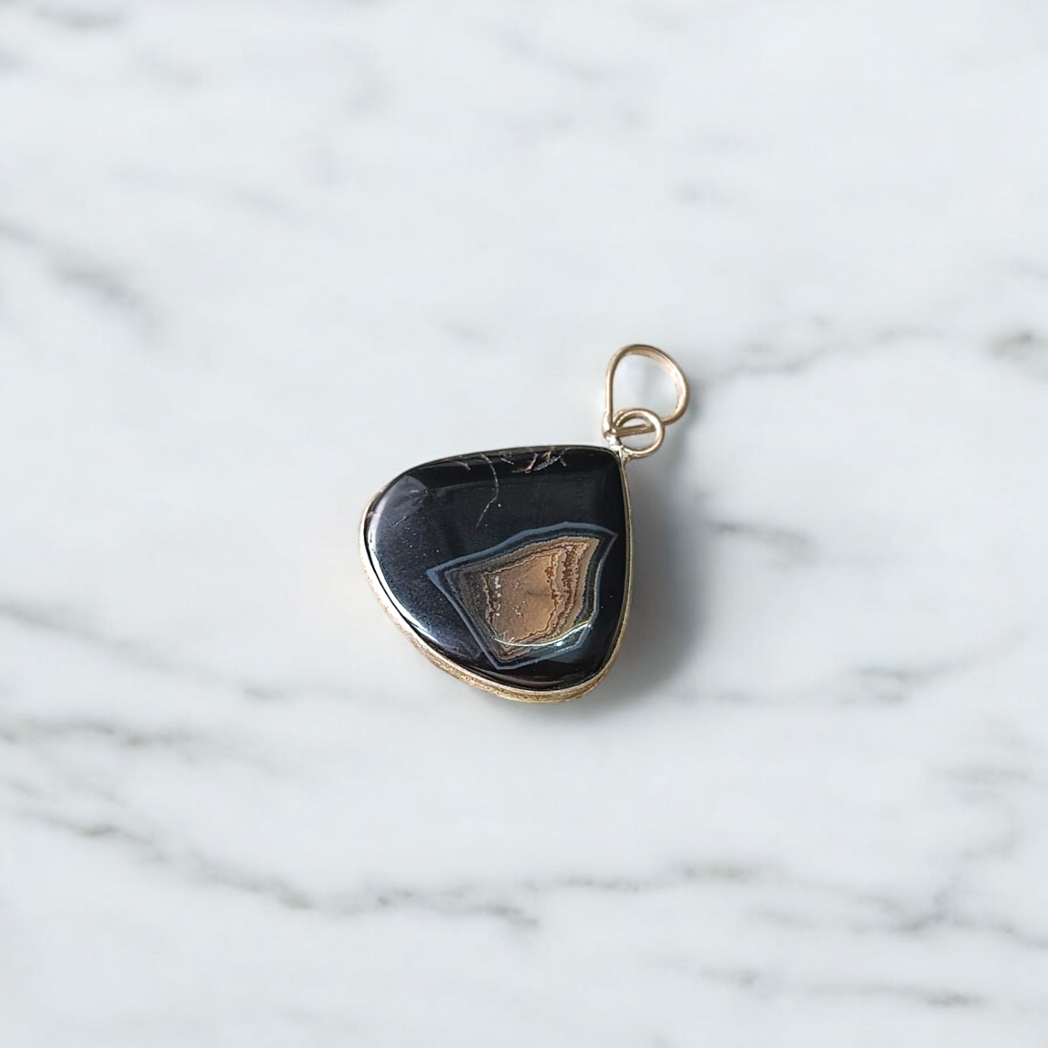 A lab-certified Natural Sulemani Pendant with a polished black agate stone set in sterling silver, displayed on a clean white background 